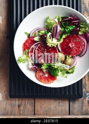 Salat mit roten Orangen, Oliven und roten Zwiebeln. Stockfoto