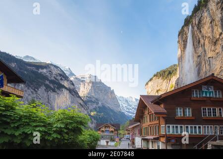 Lauterbrunnen Dorfzentrum von der Hauptstraße Dorf mit Staubbachfall Wasserfall bietet eine dramatische Kulisse an einem klaren Frühlingsnachmittag. Stockfoto