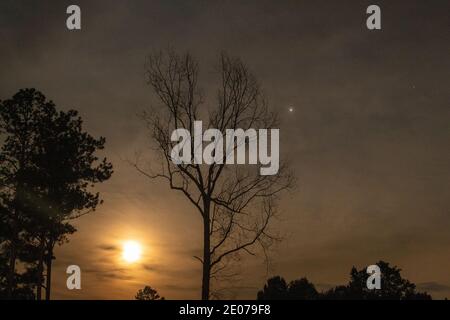 Vollmond mit Jupiter steigt vor einem Sturm. Stockfoto