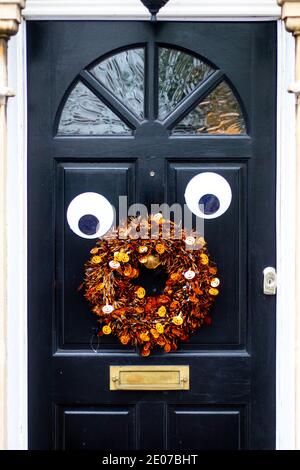 Halloween- oder Weihnachtsdekorationen an einer schwarzen Holztür Stockfoto