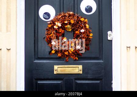Halloween- oder Weihnachtsdekorationen an einer schwarzen Holztür Stockfoto