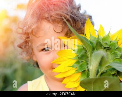 Kleiner Junge mit gelber Sonnenblume Nahaufnahme Stockfoto