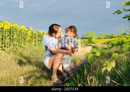 Mutter und Baby im Sonnenblumenfeld Stockfoto