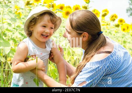 Mutter und Baby im Sonnenblumenfeld Stockfoto