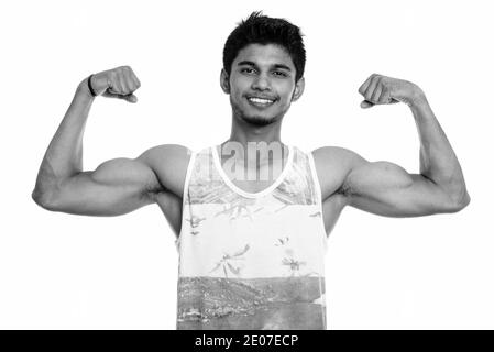 Studio shot junger indischer Mann glücklich lächelnd beim Biegen Sie beide Arme Stockfoto
