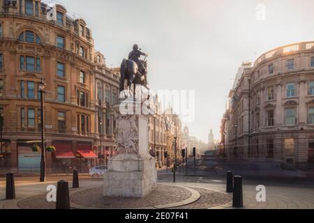 Ein Blick auf die Reiterstatue von Karl I. Trafalgar Square im Zentrum von London, wie goldenes Licht den klatschenden Gebäudetops Stockfoto