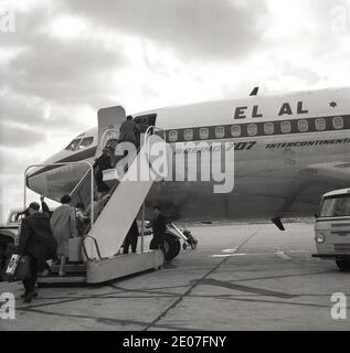 In der Geschichte der 1960er Jahre wurden Passagiere, die ein Jet-Flugzeug EL AL 707 Intercontinental besteigen, in einem Comer-Van auf der Start- und Landebahn abgesetzt, London Airport, England, Großbritannien. Gegründet im November 1948, als nationale Fluggesellschaft Israels, flog ihr erster Flug von Tel Aviv, Israel nach Rom und Paris im Jahr 1949. Stockfoto