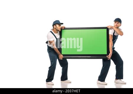 Volle Länge der multikulturellen movers stehlen Plasma-tv mit Grün Bildschirm auf weiß Stockfoto