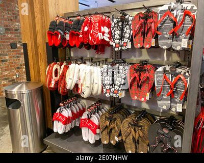 Orlando, FL USA - 15. Februar 2020: Sandalen und Pantoffeln mit dem Coca Cola Markenlogo auf ihnen im Coca Cola Store in Orlando, Florida. Stockfoto