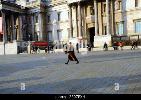 London, Großbritannien. Dezember 2020. Eine Frau geht vor die Nationalgalerie auf einen leeren Trafalgar Square. London Straßen ruhig während Coronavirus Tier 4 Einschränkungen. Kredit: JOHNNY ARMSTEAD/Alamy Live Nachrichten Stockfoto