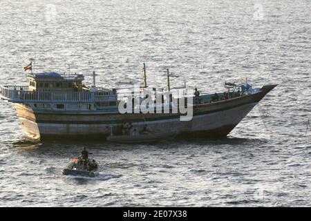 Ein Seemann an Bord eines Sicherheitsboots beobachtet ein Besuch-, Bord-, Such- und Beschlagnahmungsteam, das dem Lenkraketen-Zerstörer USS Kidd (DDG 100) an Bord der iranisch markierten Fischfangdhow Al Molai zugewiesen ist. Kidds Besuch, Vorstand, Durchsuchungs- und Beschlagnahmungsteam nahm 15 mutmaßliche Piraten fest, die in den letzten zwei Monaten eine 13-köpfige iranische Besatzung als Geisel hielten, so die Mitglieder der Besatzung. Kidd führt Operationen zur Bekämpfung von Piraterie und zur Sicherheit im Seeverkehr durch, während er im Verantwortungsbereich der 5. Flotte der USA eingesetzt wird. Arabian Sea, 5. Januar 2012. Foto von U.S. Navy via ABACAPRESS.COM Stockfoto