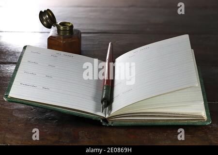 Öffnen Sie leere Tagebuch mit dib Stift und Tintenfass auf dem Desktop Stockfoto