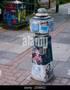 Graffiti bedeckten Poller am Anfang eines Durchgangs, der von der Brick Lane führt. Shoreditch, Tower Hamlets, East London. Stockfoto