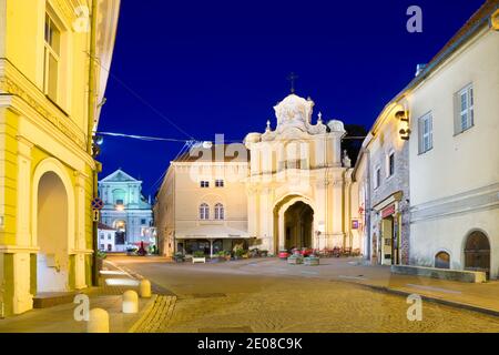 Nachtansicht der beleuchteten Ausros Vartu Straße in der Altstadt von Vilnius, Litauen. Basilianisches Tor zum griechisch-katholischen Ukrainischen Kloster der Heiligen T. Stockfoto