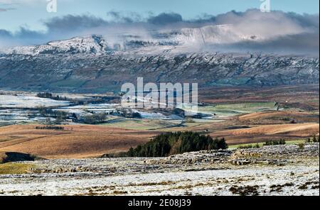 Ein Fernblick auf das Ribblehead Eisenbahnviadukt, gesehen unter einem schneebedeckten Whernside Gipfel im Yorkshire Dales National Park, Großbritannien Stockfoto