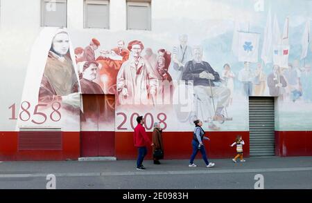 AJAXNETPHOTO. 2019. LOURDES, FRANKREICH. - FRESKO - GEMALT AUF DER SEITE EINES GEBÄUDES IN EINER STRASSE, DIE ZUR BASILIKA UND GROTTE FÜHRT, MIT BERNADETTE SOUBIROUS.FOTO:CAROLINE BEAUMONT/AJAX REF:CJP1010347 1 Stockfoto