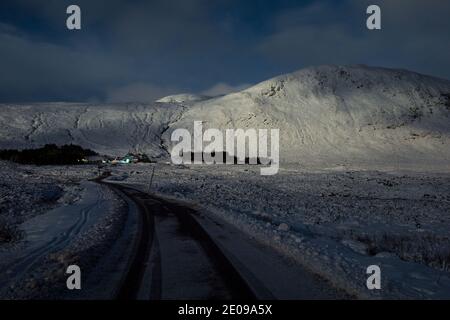 Glencoe, Schottland, Großbritannien. Dezember 2020. Im Bild: Glencoe Skigebiet beleuchtet unter der Helligkeit des schwingenden Vollmondes. Der Schnee reflektiert das Licht zurück und verursacht ein dramatisches Nachtbild. Gelbe Schneewarnung an Ort und Stelle, da mehr Schnee mit frostigen Temperaturen über Nacht erwartet wird. Quelle: Colin Fisher/Alamy Live News Stockfoto