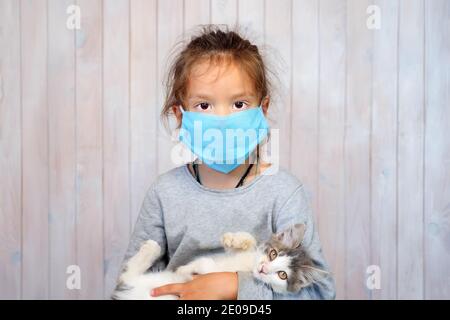 Corona-Virus und trauriges Kind. Generierung in Maske. Portrait Baby Mädchen in Maske. Kind während einer Pandemie. Kleines Mädchen und Coronavirus. Trauriges kleines Mädchen in Maske Stockfoto