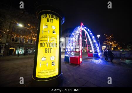 Manchester, England, Großbritannien. Dezember 2020. Szenen aus dem Stadtzentrum von Manchester am späten Abend des 30. Um Mitternacht wird die Stadt nach einer Ankündigung der Regierung heute unter Tier 4-Coronavirus-Beschränkungen gestellt. Auf einem Transparent steht "Do your bit", was die Coronavirus-Sicherheitsmaßnahmen in Piccadilly Gardens betrifft. Quelle: Callum Fraser/Alamy Live News Stockfoto