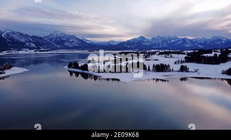 Luftdrohnenaufnahme des Forggensees in Bayern im Winter In blauer Stunde Stockfoto