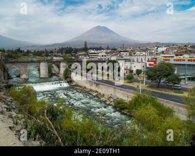 Der Rio Chili fließt durch die Stadt Arequipa, Peru. Der Vulkan Misti ist in der Ferne zu sehen Stockfoto