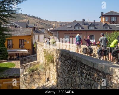 Pilger auf der römischen Brücke über den Fluss Meuelo - Molinaseca, Kastilien und Leon, Spanien Stockfoto