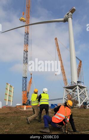 Am 16. März 2012 inspizieren Techniker die Rotorblätter einer „Haliade 150“-Windenergieanlage am Offshore-Windstandort von Alstom in Le Carnet an der Mündung der Loire in der Nähe von Saint Nazaire im Westen Frankreichs. Die LM Wind Power Group aus Dänemark entwickelte in einer strategischen Partnerschaft mit Alstom das längste jemals produzierte Windturbinenblatt, das für Alstoms neue 6-MW-Windkraftanlage für den wachsenden europäischen Offshore-Windmarkt entwickelt wurde. Die Windenergieanlage wird an Land am Standort Le Carnet getestet. Foto von Laetitia Notarianni/ABACAPRESS.COM Stockfoto