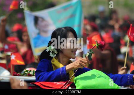 Die Demokratieaktivistin Aung San Suu Kyi aus Myanmar empfängt rote Rosen von Unterstützern in Lashio. Die Rosen sind nicht mehr frisch, weil Unterstützer seit Stunden warten und hoffen, sie zu begrüßen. Lashio, Myanmar, am 17. März 2012. Foto von Christophe Loviny/ABACAPRESS.COM Stockfoto