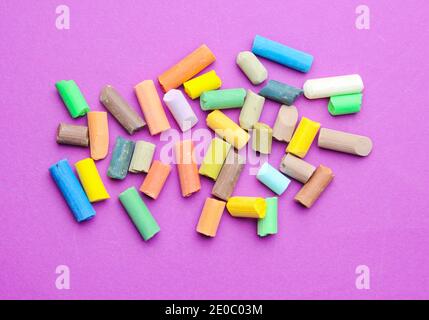 Viele farbige Pastellkreiden auf einem violetten Hintergrund. Draufsicht Stockfoto