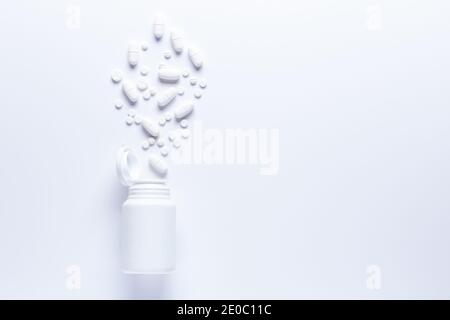 Verschüttete Pille Flasche isoliert.Draufsicht, pharmakologisches Konzept. Weiße Pillen Stockfoto
