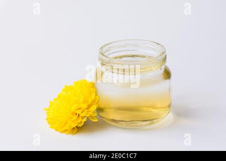Flasche mit ätherischem Öl und frischen Blumen isoliert auf weiß Hintergrund Stockfoto