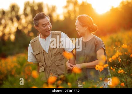 Die Blumen im älteren Paar des Glücks Stockfoto