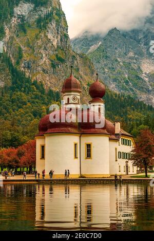Konigsee See mit St. Bartholomäus Kirche umgeben von Bergen, Nationalpark Berchtesgaden, Bayern, Deutschland Stockfoto