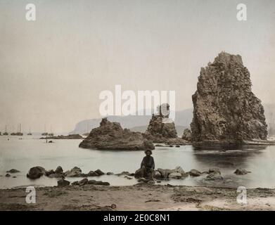 19. Jahrhundert Vintage-Fotografie - Ansicht von 'Inos Island' Ainu, Aino-Insel Japan - Ainu-Menschen waren der nördlichen Insel, die jetzt als Hokkaido bekannt ist, gegenüber ungenos - Bild zeigt Ainu-Mann mit Booten vor Anker im Hintergrund. Stockfoto