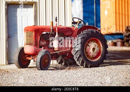 Ein alter, roter 1949 International Case Model S gasbetriebener Traktor, in einer Gasse, in Troy, Montana. Stockfoto