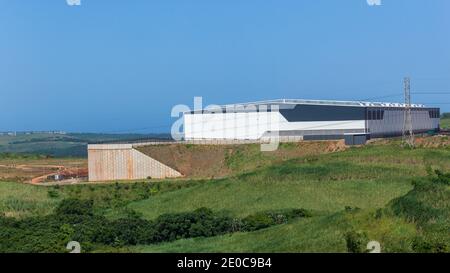 Bau neuer fertig Lagerhaus Gebäude Grundstück in Ackerland für die industrielle Expansion. Stockfoto