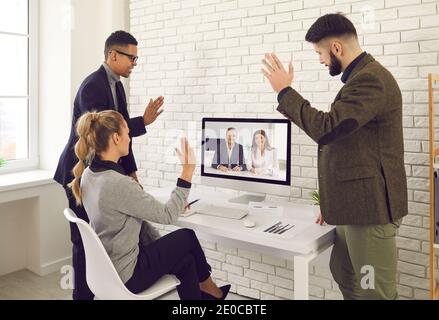 Ein Team von Geschäftsleuten ruft Kollegen für ein Arbeitsmeeting an Und winkende Hände am Bildschirm Stockfoto