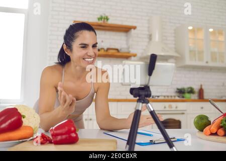 Fröhlicher Fitness-Vlogger, der Video über vegetarische Ernährung und Kochen aufzeichnet Gesunde Ernährung Stockfoto
