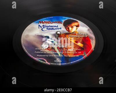 Nahaufnahme von Misplaced Childhood (ursprünglich 1985 erschienen) - eine Marillion Vinyl-Platte / LP, auf einem Plattenspieler mit der Spindel durch das Plattenzentrum. Stockfoto