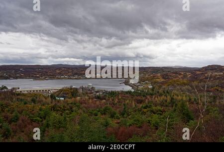 Blick auf das Fischerdorf Lochinver von der Spitze des Hügels auf Nebelwälder, mit seinem Hafen auf der Südseite des Loch Inver in der schottischen Hig Stockfoto