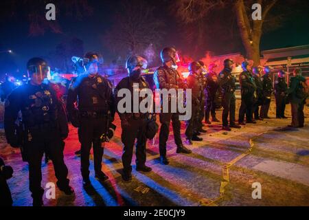 Minneapolis, Minnesota, USA. Dezember 2020. Demonstranten konfrontieren Polizei, die eine Linie hielt, während die BCA untersucht den Tatort eines Offiziers beteiligt Schießen, die das Leben von einer Person nahm. Die Drehort ist 1 Meile von wo George Floyd von der Polizei im Mai 2020 getötet wurde. Quelle: Chris Juhn/ZUMA Wire/Alamy Live News Stockfoto