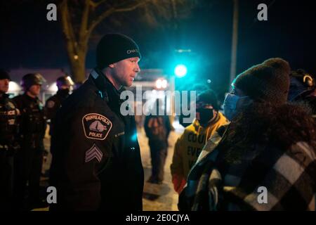 Minneapolis, Minnesota, USA. Dezember 2020. Repräsentant Aisha Gomez (rechts), ein Mitglied des Minnesota Repräsentantenhauses spricht mit einem Offizier an der Stelle eines Offiziers beteiligt Schießen, wo die Polizei nahm das Leben von 1 Person am Tag zuvor. Quelle: Chris Juhn/ZUMA Wire/Alamy Live News Stockfoto