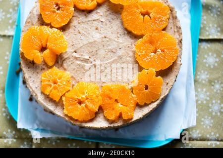 Weihnachtspudding auf Lebkuchenplätzchen mit Clementinscheiben gekrönt Stockfoto