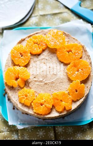 Weihnachtspudding auf Lebkuchenplätzchen mit Clementinscheiben gekrönt Stockfoto