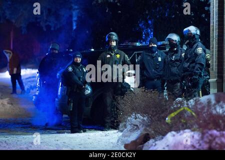 Minneapolis, Minnesota, USA. Dezember 2020. Die Polizei steht zusammen, während sie Demonstranten am Tatort eines Polizisten beobachtet, der am Vortag erschossen wurde. Die Drehort ist 1 Meile von wo George Floyd von der Polizei im Mai 2020 getötet wurde. Quelle: Chris Juhn/ZUMA Wire/Alamy Live News Stockfoto