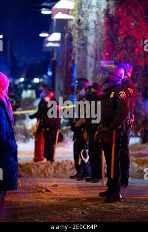 Minneapolis, Minnesota, USA. Dezember 2020. Demonstranten konfrontieren Polizei, die eine Linie hielt, während die BCA untersucht den Tatort eines Offiziers beteiligt Schießen, die das Leben von einer Person nahm. Die Drehort ist 1 Meile von wo George Floyd von der Polizei im Mai 2020 getötet wurde. Quelle: Chris Juhn/ZUMA Wire/Alamy Live News Stockfoto