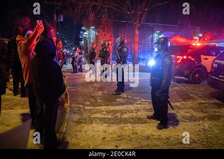 Minneapolis, Minnesota, USA. Dezember 2020. Demonstranten konfrontieren Polizei, die eine Linie halten, während die BCA untersucht den Tatort eines Offiziers beteiligt Schießen, die das Leben einer Person nahm. Die Drehort ist 1 Meile von wo George Floyd von der Polizei im Mai 2020 getötet wurde. Quelle: Chris Juhn/ZUMA Wire/Alamy Live News Stockfoto