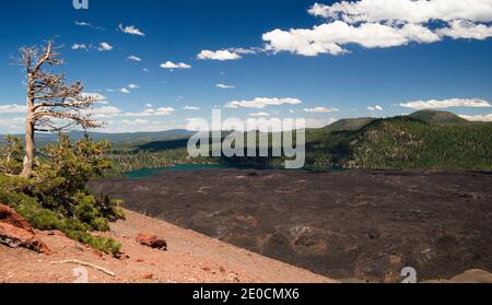 Lavabetten und (Butte Lake) im Lassen Vulkanpark. Türkisblauer See, blauer Himmel und dunkle Lave im Sommer. Stockfoto