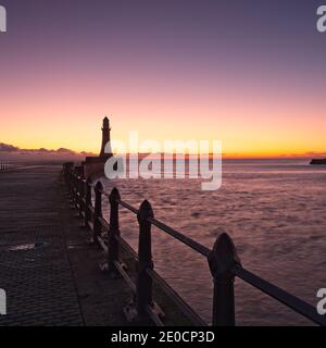 Sonnenaufgang am Roker Pier und Leuchtturm, der von der Nordseeküste bei Sunderland, Tyne und Wear, Nordostengland, reicht. Stockfoto