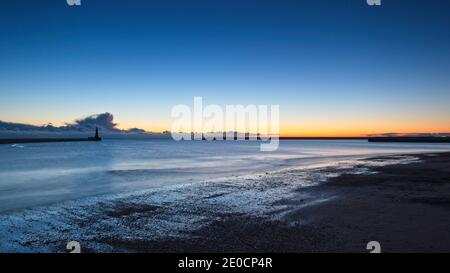 Sonnenaufgang am Roker Pier und Leuchtturm, der von der Nordseeküste bei Sunderland, Tyne und Wear, Nordostengland, reicht. Stockfoto